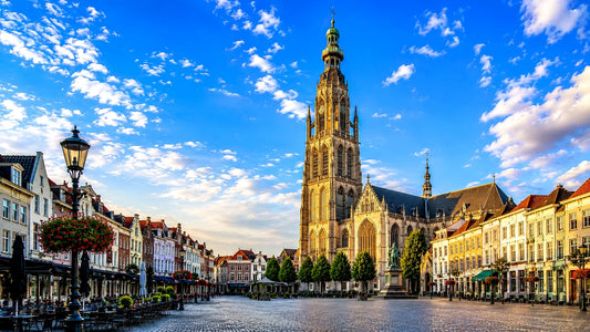 breedbeeldfoto van de Grote Kerk op de Grote Markt in Breda, Nederland, met historische gevels en sfeervolle architectuur bij zonsondergang – professionele landmarkfoto voor meubels herstofferen en meubelstoffering in Breda