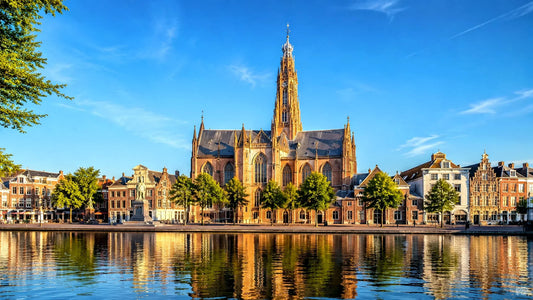 breedbeeldfoto van de Grote of Sint-Bavokerk aan het Spaarne in Haarlem, Nederland, met historische gebouwen en weerspiegeling in het water – stijlvolle landmarkfoto voor meubels herstofferen en meubelstoffering in Haarlem