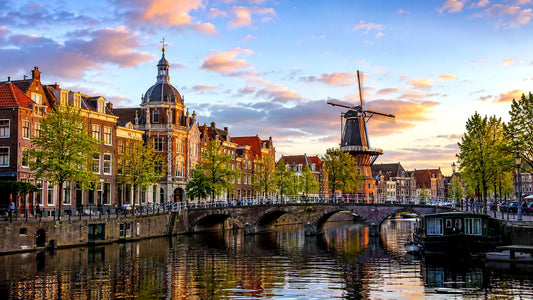 Breedbeeldfoto van de historische grachten, bruggen en molen De Valk in Leiden, Nederland, bij zonsondergang – sfeervolle 8K landmarkfoto voor meubels herstofferen en meubelstoffering in Leiden